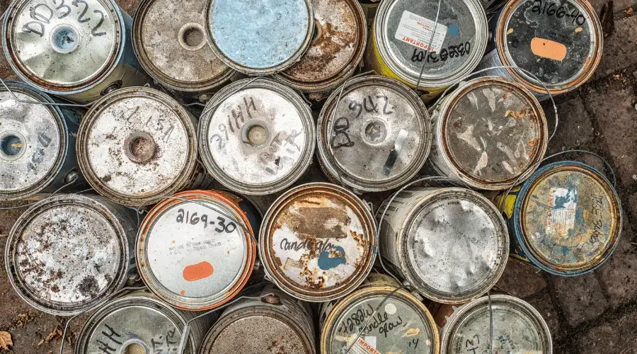 top view of old paint cans with dates scribbled on the top of each can